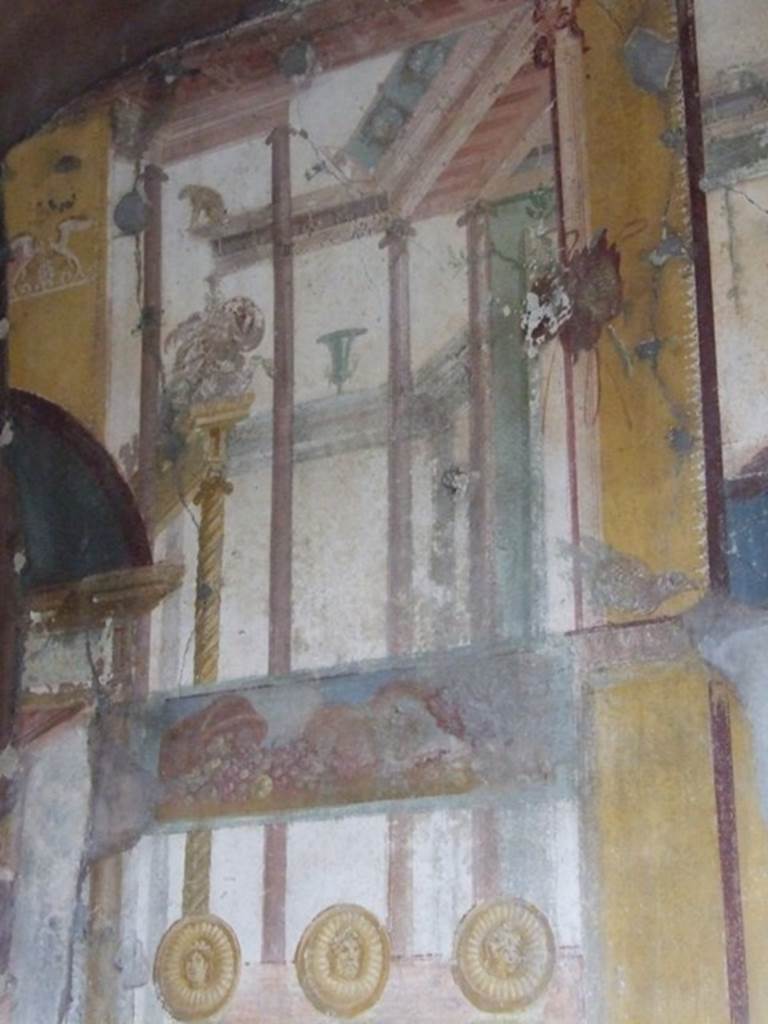 IX.1.7 Pompeii. December 2007.
Painted upper north wall of triclinium with architectural features, a painted basket of overturned fruit and three faces in gold medallions, representing Juno, Jove and Minerva.