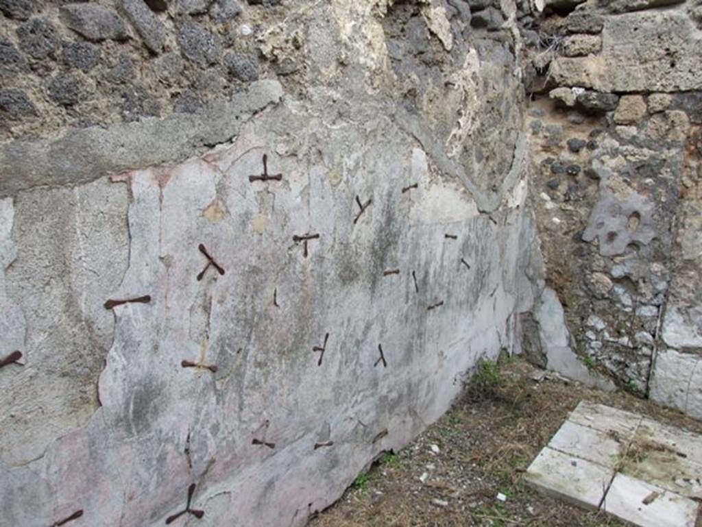 IX.2.16 Pompeii. December 2007. North wall of triclinium, the room on east side of staircase, and south of corridor. Note the system for securing the plaster to the walls adopted in the first years of the 20th century under Spinazzola. In this room the zoccolo was colourless, the middle zone of the walls were red with traces of panels separated by compartments.