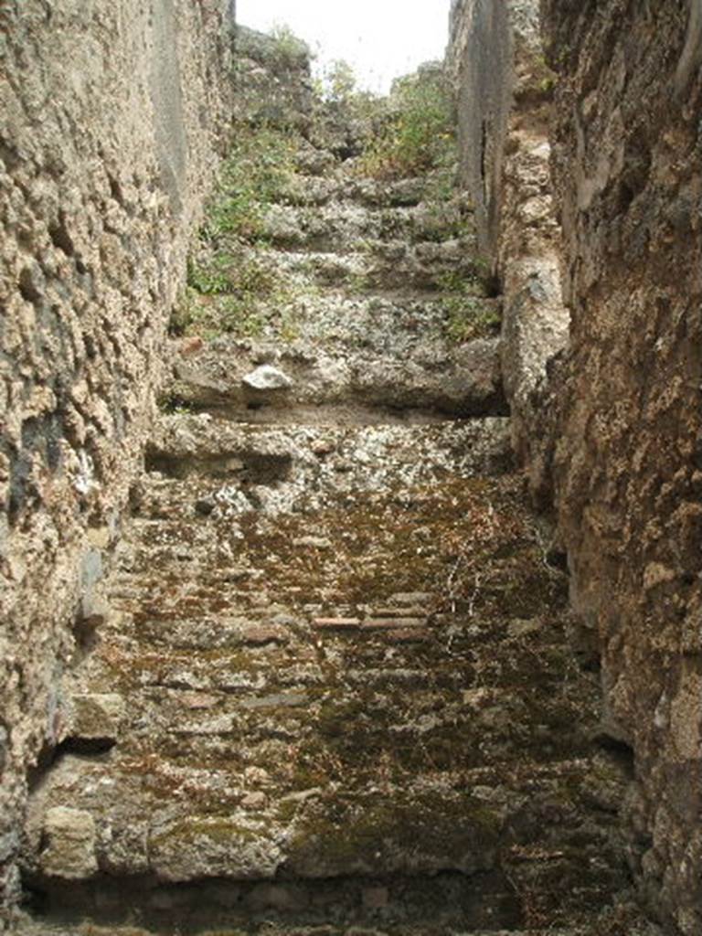 IX.2.27 Pompeii. May 2005. Stairs to upper floor, on east side of peristyle.
According to Trendelenburg,
“The room adjacent to the triclinium was regarded as a cubiculum, due to a stripe in the floor composed of black and white stones, which indicated the place where the bed would have been.
Then followed an opening for the stairs, and at the end of this side another room with a spacious entrance.
See Bullettino dell’Instituto di Corrispondenza Archeologica (DAIR), 1871, p.178