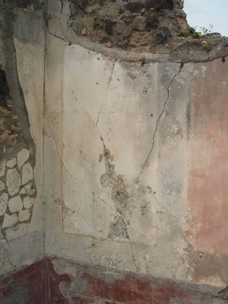 IX.5.18 Pompeii. May 2005. Room l. Room to the south of Oecus in north east corner. Remains of painted plaster in north west corner.