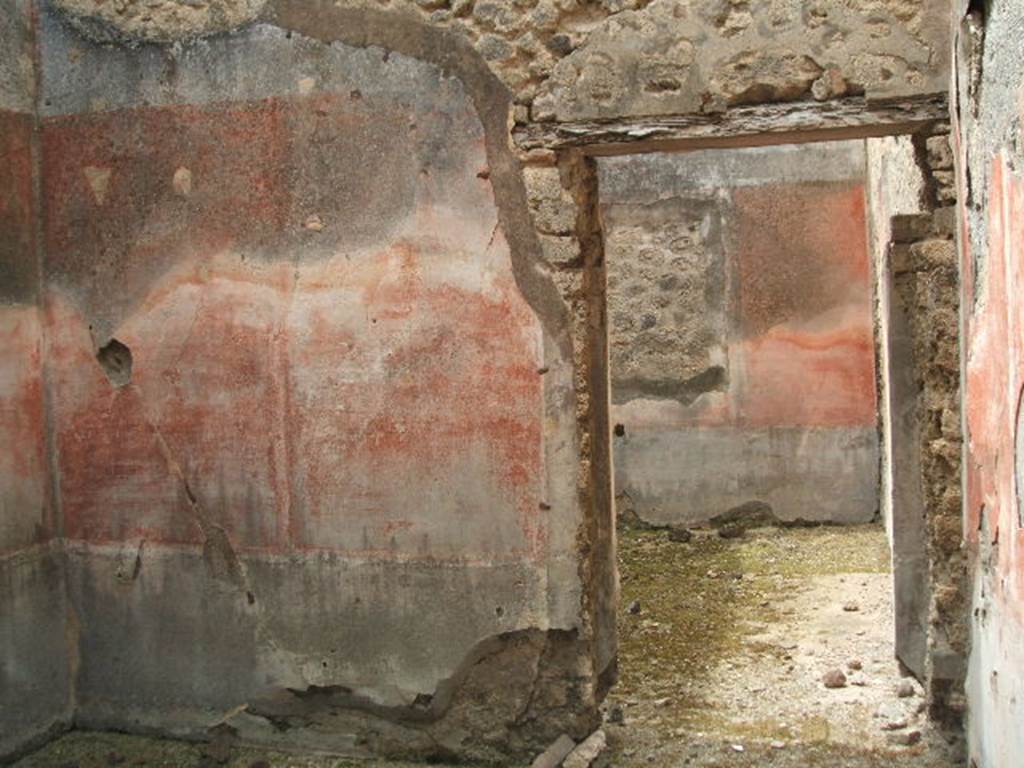 IX.5.18 Pompeii. May 2005. Two rooms in south-west corner. Room d, looking west to doorway to room e. The red middle zone of the west wall was separated from the black zoccolo by a horizontal pattern.