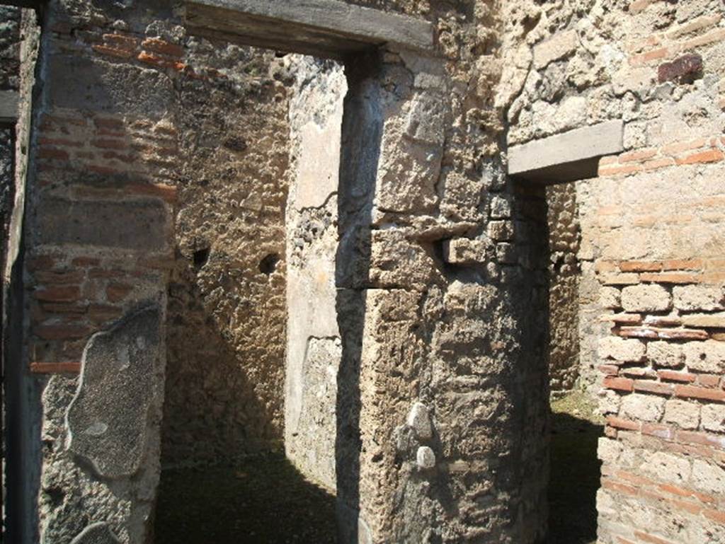 IX.7.20 Pompeii. May 2005.
Looking west through doorway to small room (b) or cupboard on north side of street entrance doorway.
On the right of the photo is the doorway to room (a) with stairs to upper floor.