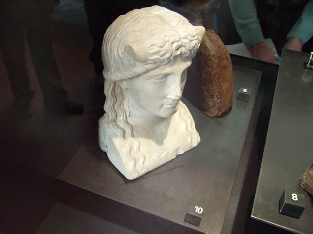 Marble statuette of Iside-Io? Found in IX.7.23, according to Naples Museum card.
Now in Naples Archaeological Museum. Inventory number 119584.
According to Jashemski and Dwyer, this was found in the atrium of IX.7.20, but probably belonged to the peristyle.
It was discovered on 28th October 1880, and described as –
Bust for a herm. White marble. Height m.0.21.
The back of the bust is flat and the sides show cuttings for cross-bars.
A river god, with bull’s horns protruding from above temples.
Hair parted down the middle, descends in wavy tresses to chest.
See Jashemski, W. F., 1993. The Gardens of Pompeii, Volume II: Appendices. New York: Caratzas. (p.241)
See Dwyer E., 1982. Pompeian Domestic Sculpture, Rome: Bretschneider, pp.71-78.