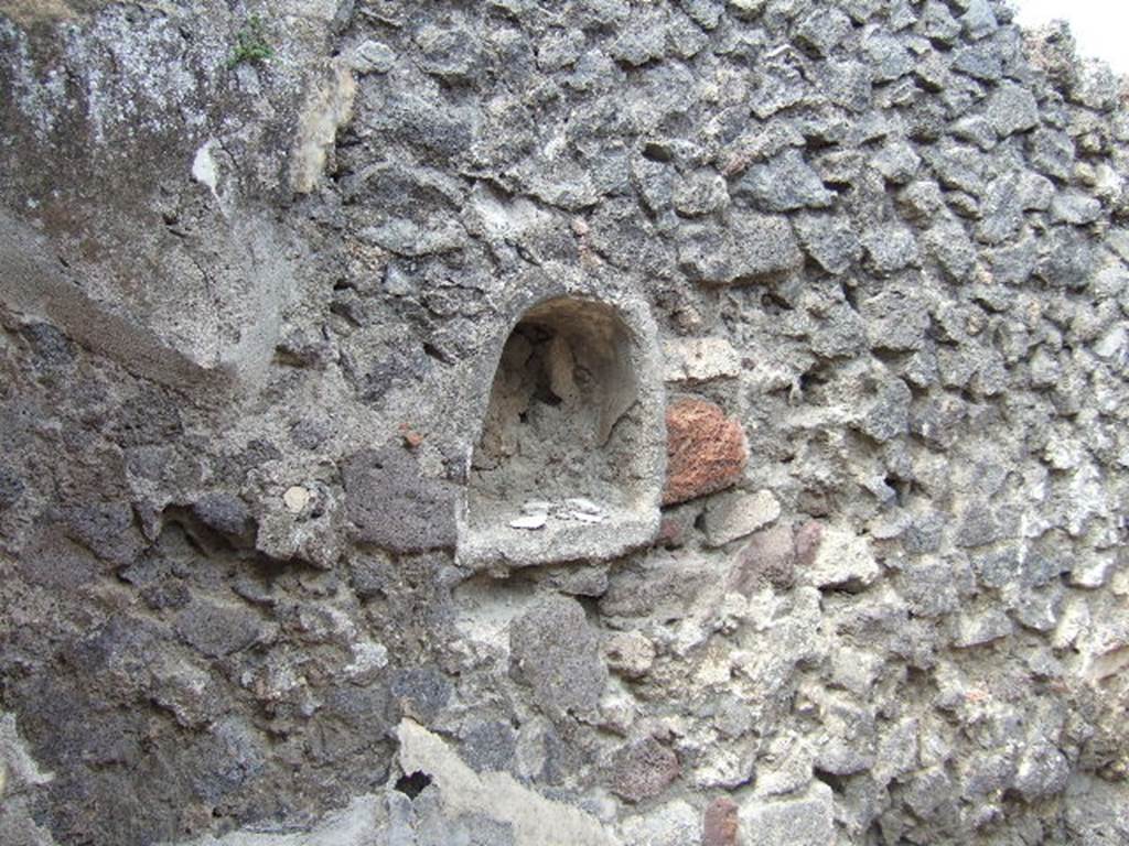 IX.9.6 Pompeii. May 2006. Niche in west wall of cubiculum. According to Boyce, this had walls of white stucco decorated with green, yellow and violet spots, probably representing flowers.
See Boyce G. K., 1937. Corpus of the Lararia of Pompeii. Rome: MAAR 14. (p. 91) 
