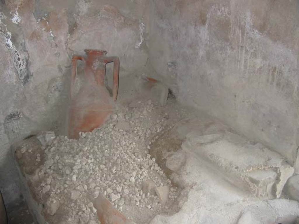 IX.11.2 Pompeii. May 2003. Amphora and remains of shelving at east end of counter. Photo courtesy of Nicolas Monteix.