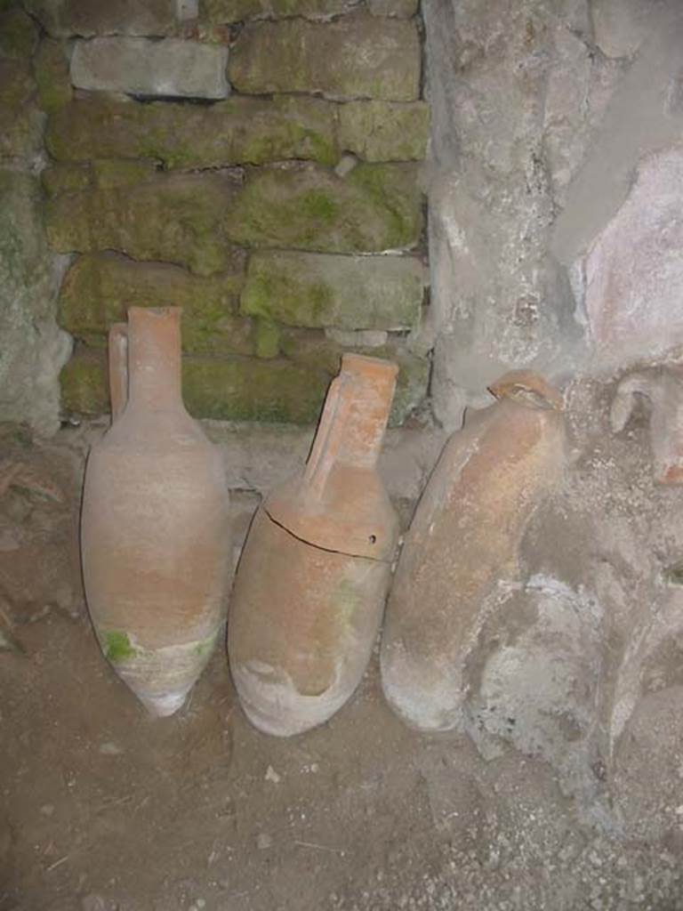 IX.11.2 Pompeii. May 2003. Amphorae in front of blocked door at centre of east wall. Photo courtesy of Nicolas Monteix.