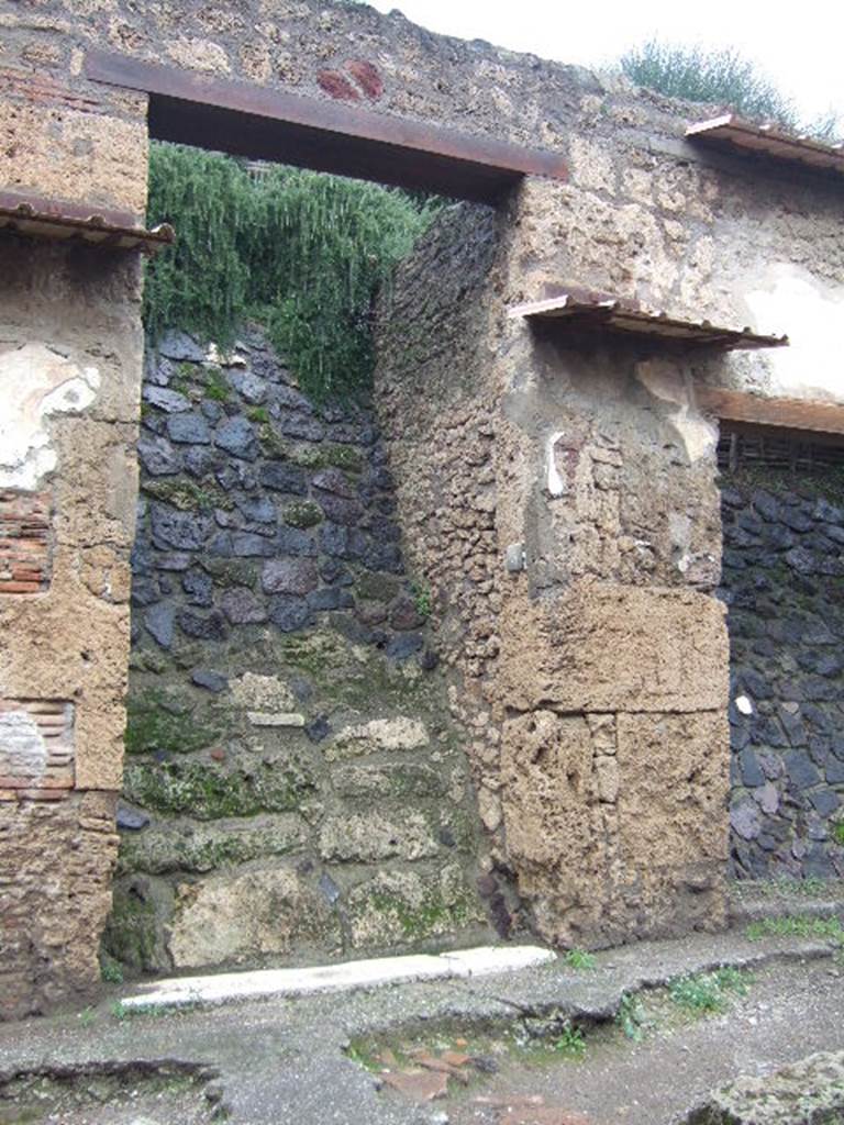 IX.13.5 Pompeii.December 2005. Entrance doorway.  There was a small painting on either side of the doorway.   These were surrounded by the chessboard decoration still visible at IX.13.6.  Aeneas was on the right hand side of the door and Romulus on the left. See Fröhlich, T., 1991, Lararien und Fassadenbilder in den Vesuvstädten.  Mainz: von Zabern.  (F72, p.339/40).
