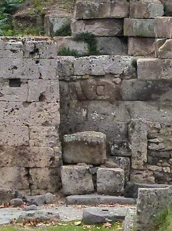 Two altars at Pompeii Vesuvian Gate. September 2011. West wall of gate and site of two altars. According to Sogliano, the larger altar was in the wider part of the recess [d on the plan]. It had edges in relief and was dressed entirely in plaster and with a painted representation which was completely unrecognizable. Next to this altar there was another [e on the plan], in a narrow part to the right (north) at the rear. It was much smaller, and also had an edge in relief. They were certainly devoted to worship of Lari Pubblici and to the guardian deity of the gate, whose representations would have been painted on the walls, in which the two altars were huddled. See Notizie degli Scavi di Antichit, 1906, p. 97-100.
The three gate stones can be seen on the ground to the left. Detail from photo courtesy of Michael Binns.