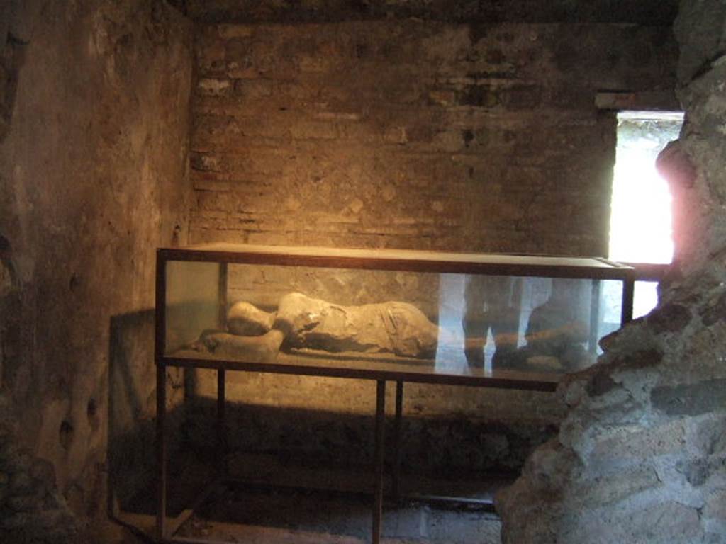 Villa of Mysteries, Pompeii. May 2006. Victim 25. Room 35, from room 34.
As the ostiarius, he had taken refuge in his closed room to die on his own bed, sheltered from the roaring storm raging outside.
He had stretched out, desperately lonely, on that poor bed, and had remained lying on his right side, his arms raised to rest his head on them as if to hide the terrible contraction of his mouth and jaws in the last breath of asphyxia.
Come l'ostiario, in consegna, si era rifugiato nel suo chiuso stanzino per morire sul proprio giaciglio, al riparo della scrosciante tempesta che infuriava al di fuori.
Si era disteso, disperatamente solo, su quel povero giaciglio, e vi era rimasto coricato sul fianco destro, le braccia portate in alto per appoggiarvi il capo quasi a nascondere la spaventosa contrazione della bocca e delle mascelle nell'ultimo anelito dell'asfissia.
See/Vedi Maiuri A., 1967. La Villa dei Misteri. Istituto poligrafico dello stato/libreria dello stato, p.10.
