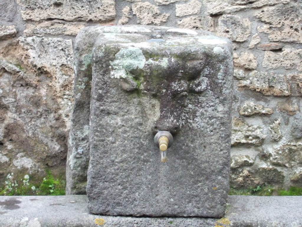 Fountain on Via dell Abbondanza between II.1.2 and II.1.3. December 2005. Relief of head of bull or ox.