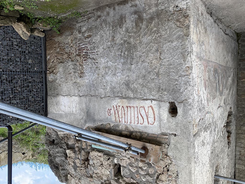 Pompeii Fountain at V.8, on north-east side of junction. November 2021. 
Painted graffiti on west end of south wall near the street shrine, on north side of Vicolo delle Nozze d’Argento. 
Photo courtesy of Joonas Vanhala.
