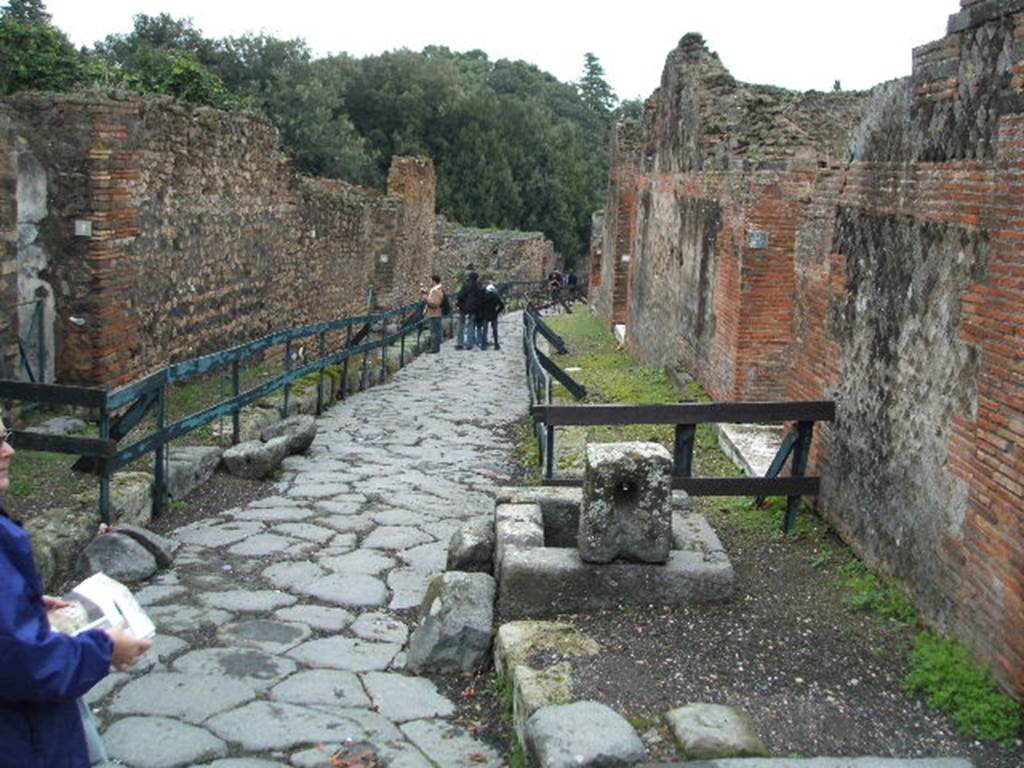 VIII.6.1 Pompeii, on left. December 2004. Vicolo della Regina looking east with fountain at VIII.2.29, on right.