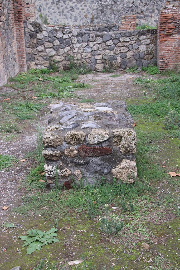 I.1.4 Pompeii. October 2024.
Looking east towards large masonry bench in the centre of the shop-room. Photo courtesy of Klaus Heese.