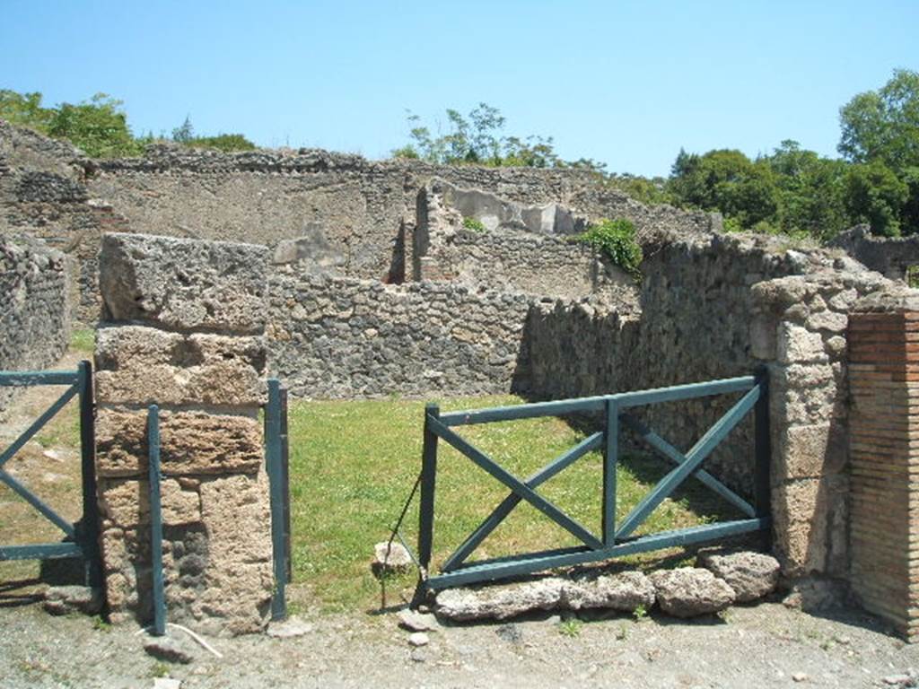 I.2.5 Pompeii. May 2005.  
Looking east across shop bombed in 1943, only the external rebuilt walls remain.
According to Eschebach, it contained a shop-room, two rustic rear rooms and a latrine.
See Eschebach, L., 1993. Gebäudeverzeichnis und Stadtplan der antiken Stadt Pompeji. Köln: Böhlau. (p.15)
