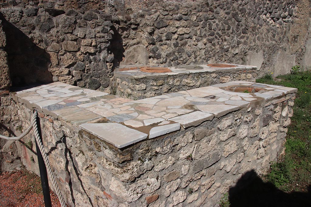 I.2.8 Pompeii. October 2024. Looking north-east across serving counters. Photo courtesy of Klaus Heese.