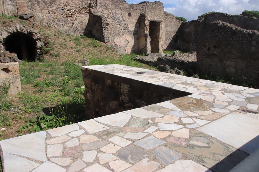 I.2.13 Pompeii. October 2024. Looking south-east across counter, towards east side of atrium of I.2.10. Photo courtesy of Klaus Heese.