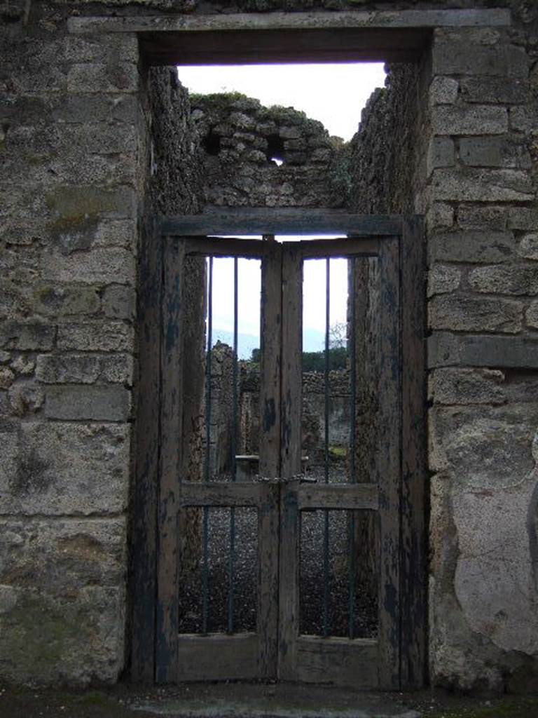 I.3.24 Pompeii. December 2005. Entrance doorway. According to Garcia y Garcia, a plaster cast of a portion of the entrance doorway with two shutters (leafs), half closed, with lock, door-bolt, hinge and iron doorlock, and provenanced from the doorway at I.3.24, used to be seen in the Antiquarium prior to the 1943 bombing.
See Garcia y Garcia, L., 2006. Danni di guerra a Pompei. Rome: LErma di Bretschneider, (p.184, fig.427).

