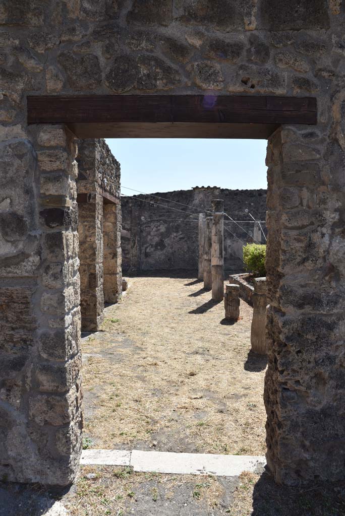 I.4.25 Pompeii. September 2020. 
Lower Peristyle 32, looking south through doorway towards east portico, from Middle Peristyle 17
Foto Tobias Busen, ERC Grant 681269 DÉCOR.

According to Jashemski –
“The long wall separating the centre (Middle) peristyle from the south (Lower) peristyle has six windows and two doors which afforded a magnificent view into the southern peristyle. The six windows each corresponded to an intercolumniation in the southern peristyle, which would indicate that in the earlier period this peristyle had been considered the more important. The twenty columns of the portico were made of brick and Sarno limestone and faced with stucco. The upper parts were fluted, the lower parts were left plain. A marble puteal stood in the portico near the north-east corner column. A gutter outlined the edges of the garden.”
See Jashemski, W. F., 1993. The Gardens of Pompeii, Volume II: Appendices. New York: Caratzas. (p.31).
