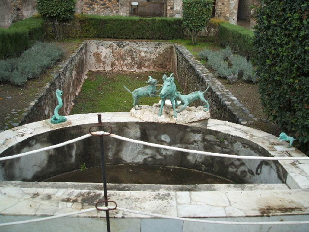 I.4.25 Pompeii. December 2004. Middle Peristyle 17, looking east across semi-circular marble basin and pool.
Around the marble basin are bronze replicas of statues of a cobra, a lion and a boar being attacked by dogs.
