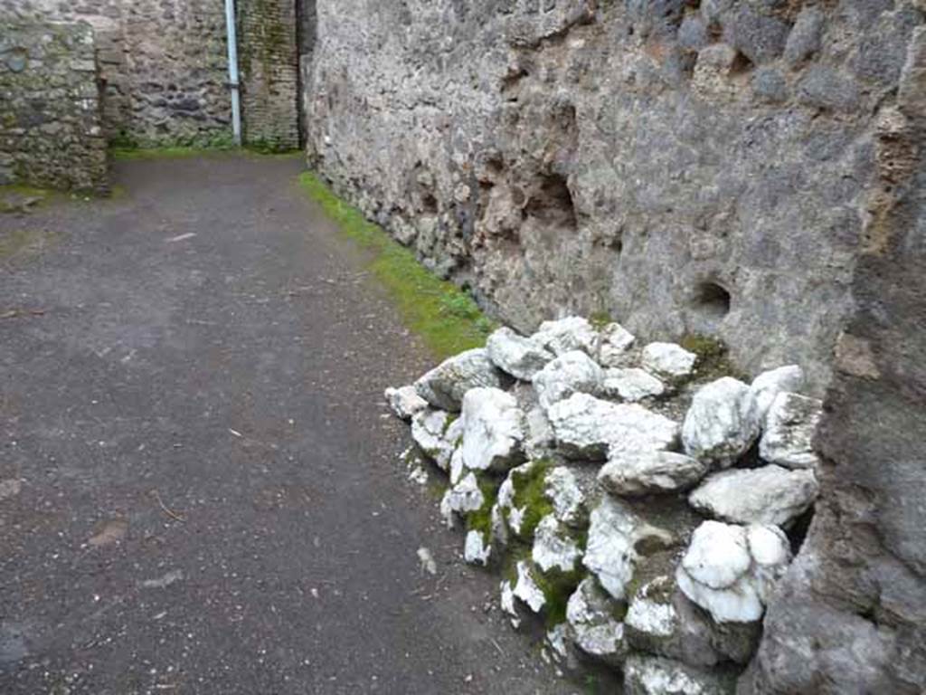 I.6.4 Pompeii. May 2010. Room 13, looking east, with more building material against south wall.