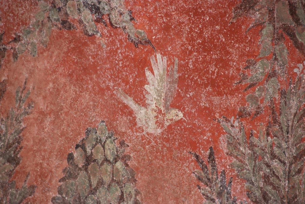 I.6.15 Pompeii. October 2023.
Room 9, detail of painted bird on south side of window in east wall of small garden. Photo courtesy of Klaus Heese.