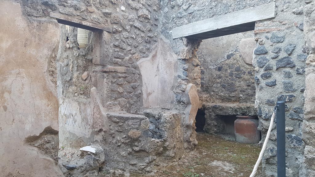 I.7.19 Pompeii. August 2023.
Small room on north side of corridor with two doorways, one to garden area, the other to kitchen. Photo courtesy of Maribel Velasco.