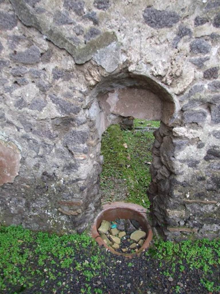 I.8.16 Pompeii. 
Looking west through a hole in the wall from I.8.14, into the uncovered area, described as having a kitchen podium, and the channel to convey the waters from the adjoining house at I.8.14. 
