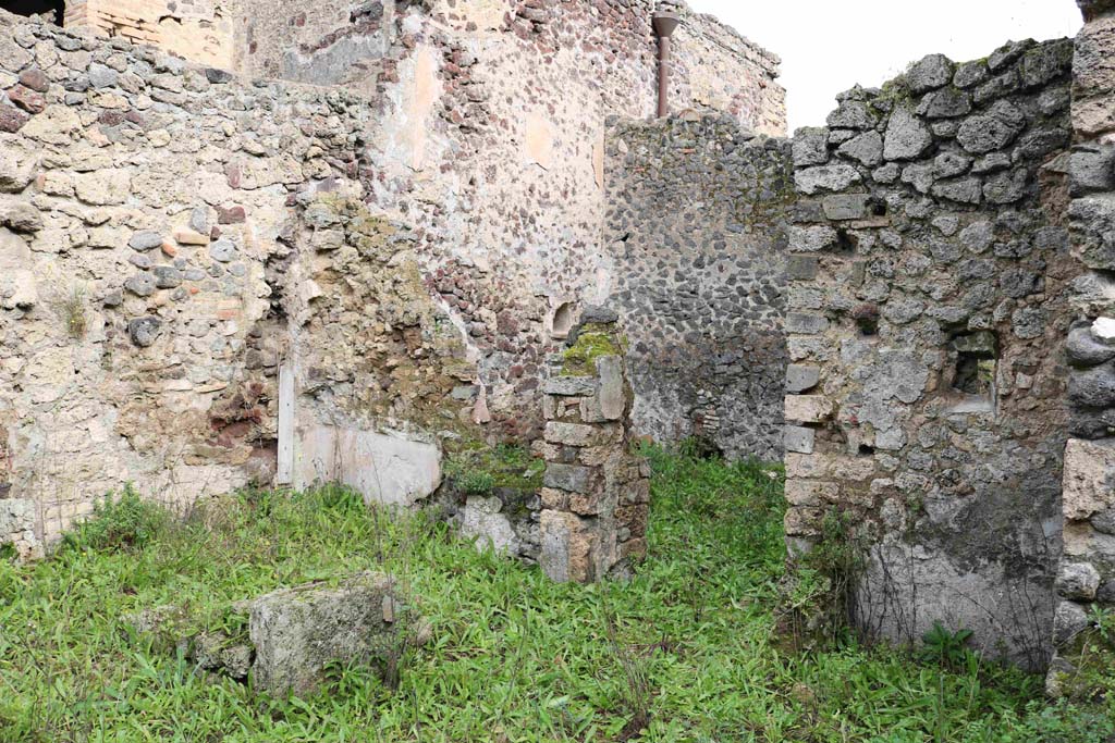 I.8.16 Pompeii. December 2018. Looking north-east across room/garden towards doorway to kitchen area. Photo courtesy of Aude Durand.
The outer west wall of the kitchen area, centre left with remaining plaster, would have been the east wall of a small room, possibly a cubiculum.
The doorway to this room would have been at the south end, next to the kitchen doorway. 
