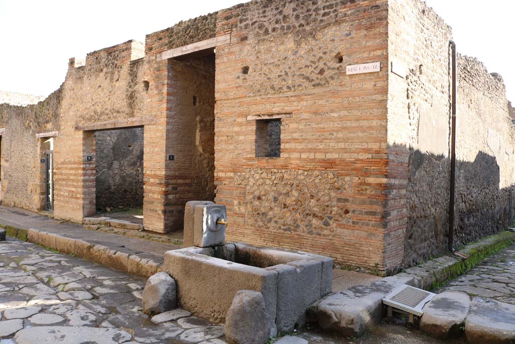 I.9.1 Pompeii, December 2018. 
Looking south-east on Via dellAbbondanza towards doorway at the rear of the fountain. Photo courtesy of Aude Durand.
