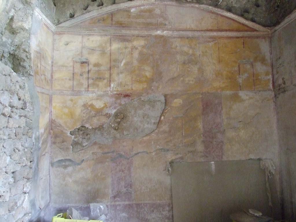 I.9.3 Pompeii. March 2009. Room 10, looking towards the east wall.
According to PPM, on the left can be seen a hole made by the ancient searchers on the north wall.
The middle zone of the east wall was yellow, with a central aedicula which contained a painting of Adone ferito (now faded).
The upper area was also yellow with a painting of Venus Pompeiana in the centre aedicula.
In the side panels of the upper area, were hanging buckets separated by architectural views, garlands, borders with “carpet” pattern, and dolphins in the corners, and holes made by the support beams for the vaulted ceiling.
