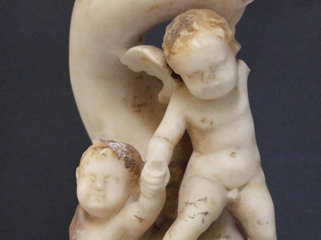 I.9.14 Pompeii. 2009. Marble fountain statuette. Two Amorini riding on dolphin.
Detail of a cupid. SAP inventory number 8128. Found in 1951.