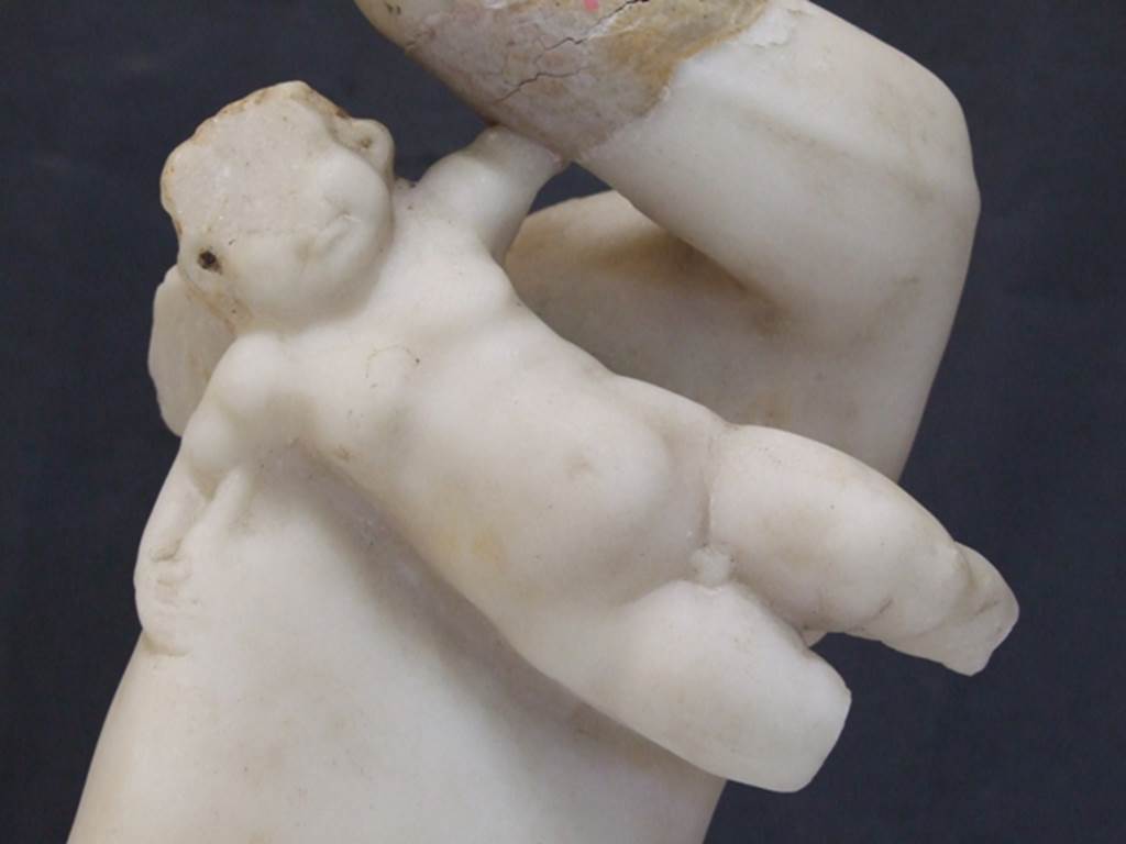 I.9.14 Pompeii. Marble fountain statuette. Amorino riding on dolphin. Detail of amorino. SAP inventory number 8129. Found in 1951.