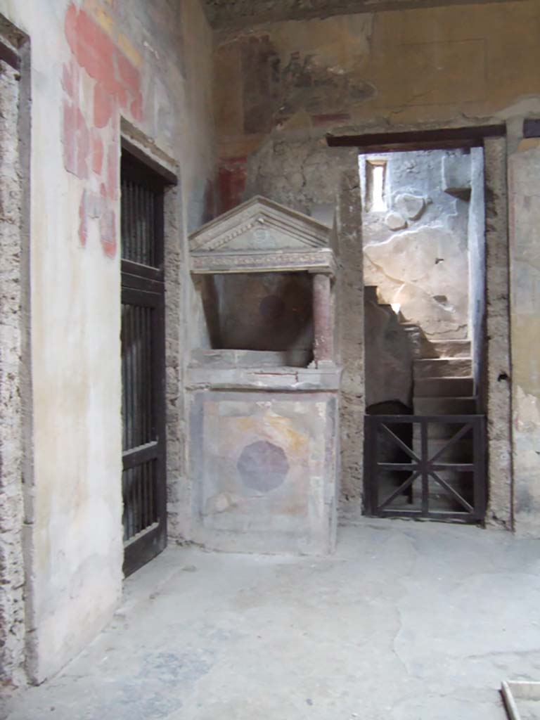 I.10.4 Pompeii. May 2006. North-west corner of atrium, with doorway to room 5, the lararium and doorway to room 2.