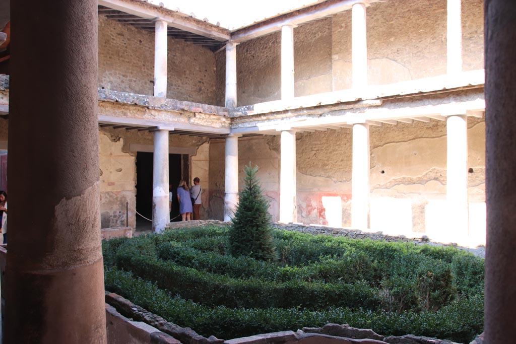 I.10.11 Pompeii. October 2022. 
Peristyle 10, looking towards north-west corner with large doorway from room 8, triclinium. Photo courtesy of Klaus Heese. 
