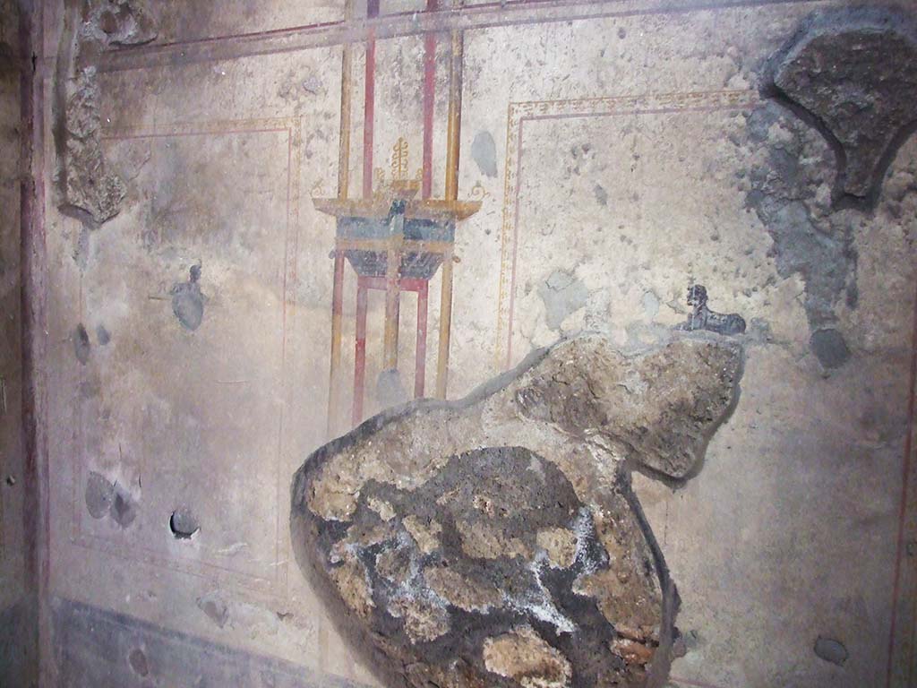 I.10.11 Pompeii. March 2009. Room 7, south wall of cubiculum with a painting of a sphinx in both side panels. 
In the north wall, on both west and east sides of the doorway, a painted sphinx can also be seen.    
On the west wall, there were also small painted panels; at the south end were painted ducks among rushes, and at the north end was a painted crocodile. The east wall also had a painted panel with a crocodile at the north end, and a panel with ducks at the south end.
According to PPM –
In room 7, there was a simple decoration painted on a white background with other architectural views and small panels of sphinxes and crocodiles or ducks among rushes. 
See Carratelli, G. P., 1990-2003. Pompei: Pitture e Mosaici. II. (2). Roma: Istituto della enciclopedia italiana, (p.469).