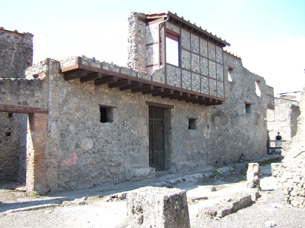 I.10.18 Pompeii. September 2005. 
Looking north towards entrance doorway with a window on either side overlooking roadway from rooms on either side of entrance corridor.
