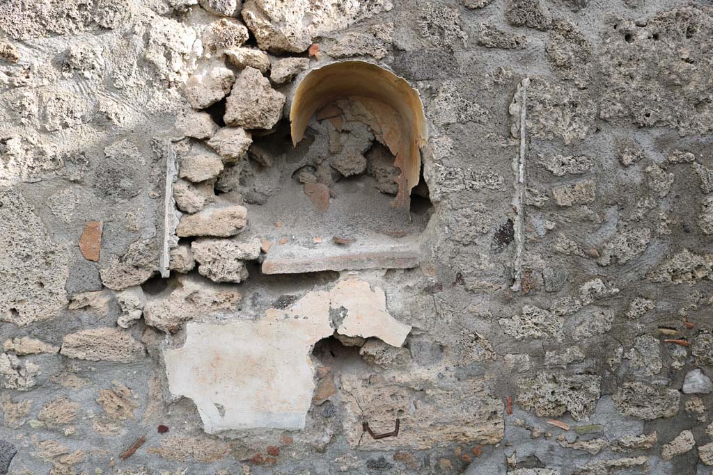 I.11.10 Pompeii. December 2018. Detail of lararium in east wall, with remaining stucco below. Photo courtesy of Aude Durand.