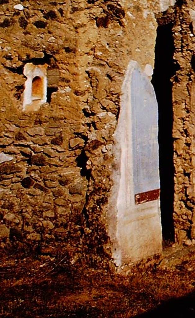 I.11.12 Pompeii. 1964. Painted plaster on doorway to small room, on left, and south wall with niche. 
Detail from photo by Stanley A. Jashemski.
Source: The Wilhelmina and Stanley A. Jashemski archive in the University of Maryland Library, Special Collections (See collection page) and made available under the Creative Commons Attribution-Non Commercial License v.4. See Licence and use details.
J64f1971
