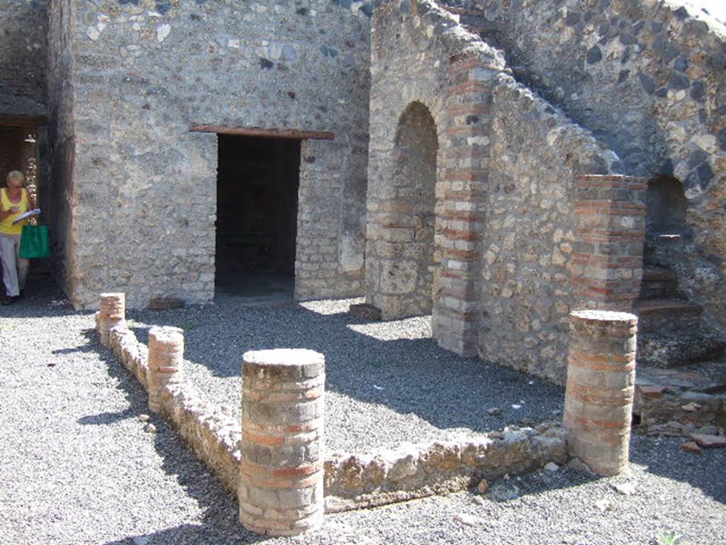 I.11.14 Pompeii. September 2005. Looking east across the peristyle garden.
According to Jashemski, this was enclosed by a portico on the west, north and east supported by four columns. These columns were joined on the west and north by a low wall. At the time of excavation, there was a gutter and in the west portico, a terracotta cistern puteal, neither are now visible.
See Jashemski, W. F., 1993. The Gardens of Pompeii, Volume II: Appendices. New York: Caratzas. (p.52) 

On the left can be seen the corridor to the rear of the house, and doorway to Oecus, in the centre.