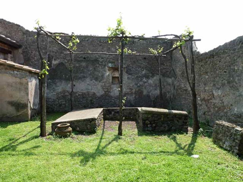 I.13.2 Pompeii. May 2010. Summer triclinium, looking south. The small building on the east (left side) may have been a sacellum.
See Jashemski, W. F., 1993. The Gardens of Pompeii, Volume II: Appendices. New York: Caratzas. (p.56).  There is a small masonry table against the middle of the west wall, (right side).
