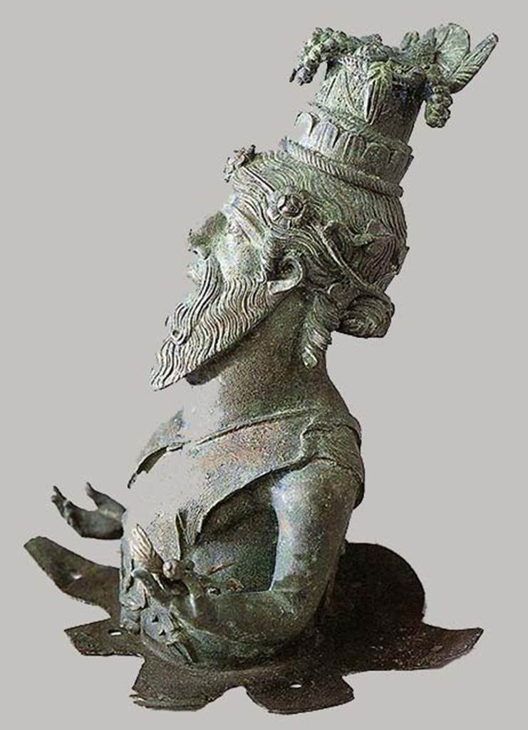 I.13.9 Pompeii, Bust of Dionysus-Sabazius, side view. SAP inventory number 11471.
According to Berry, he wears a tall fruit basket as a hat.
From it overflow grapes, figs, plums, ears of wheat and a loaf of bread, all symbols of fertility.
The figure was originally mounted on a wooden pole.
See Berry, J., 2007. The Complete Pompeii. London: Thames & Hudson, p. 200.