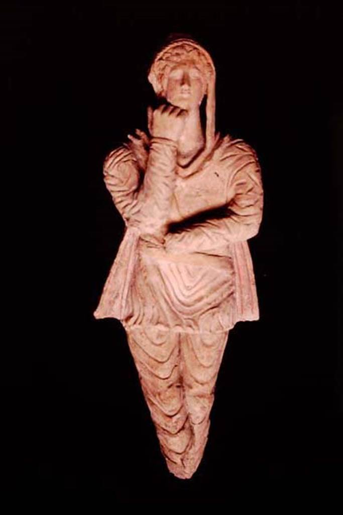 Pompeii, 1982 or 1983. Terracotta statuette of Attis discovered in the area next to the wall of the ancient well.   
This second statuette has the arms and legs positioned inverted and the hand that supports the chin is more closed compared to 10309. 
SAP inventory number 10310.
Source: The Wilhelmina and Stanley A. Jashemski archive in the University of Maryland Library, Special Collections (See collection page) and made available under the Creative Commons Attribution-Non Commercial License v.4. See Licence and use details.
J80f0500
See DAmbrosio A. and Borriello M., 1990. Le terrecotte figurate di Pompei: SAP cat. 4. Roma: LErma di Bretschneider, p. 24, n. 17, Tav. V.

