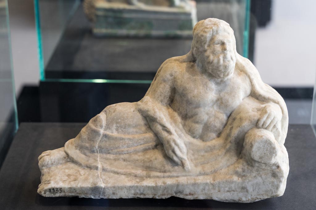 II.2.2 Pompeii. January 2023. 
Room “k”. White marble statuette of a river god. Found on the east side of the upper euripus near the biclinium in the garden in 1920. 
On display in exhibition in Palaestra. Photo courtesy of Johannes Eber.
