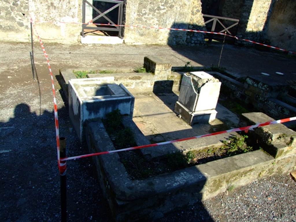 II.2.2 Pompeii. March 2009. Room 2, atrium.  Looking east across impluvium and fountain. 
The east and west sides of the impluvium were badly damaged by bombing in 1943 and have been rebuilt.
See Jashemski, W. F., 1993. The Gardens of Pompeii, Volume II: Appendices. New York: Caratzas. (p.78)
