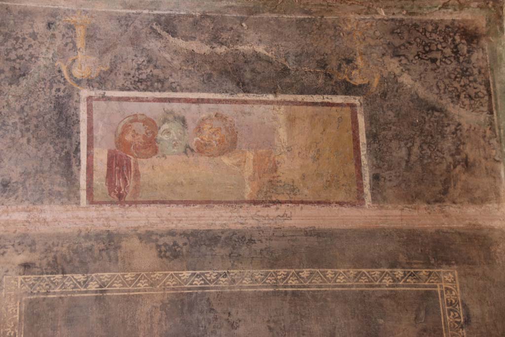 II.3.3 Pompeii. September 2017. Room 6, detail of painted panel with masks from upper south wall.
Photo courtesy of Klaus Heese.

