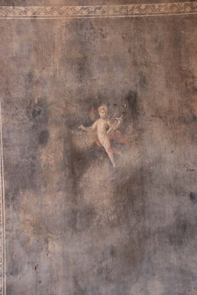 II.3.3 Pompeii. September 2017. 
Room 6, painted flying cupid from west end of south wall. Photo courtesy of Klaus Heese.
