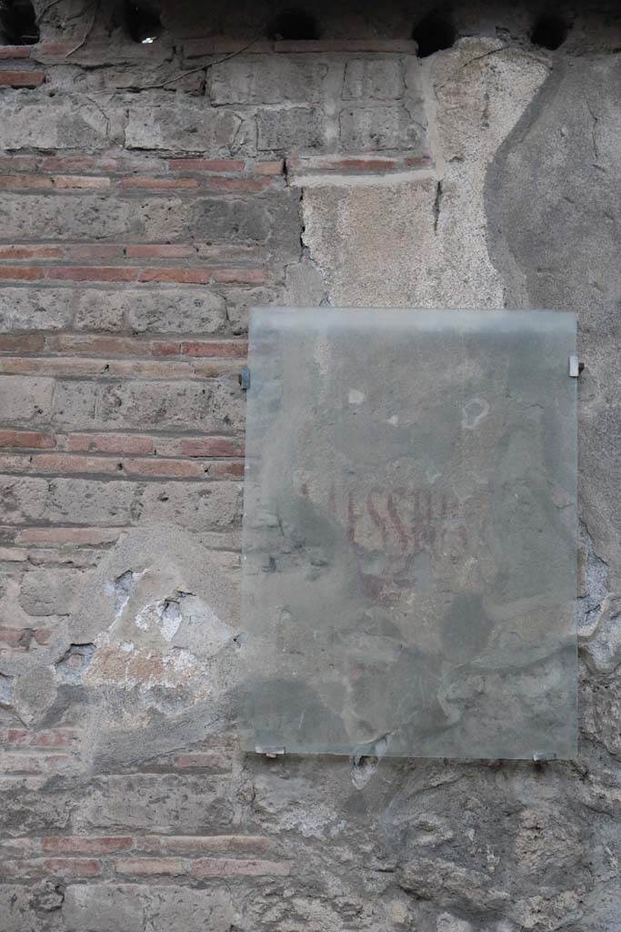 Via di Castricio, September 2018. Photo courtesy of Aude Durand.
Graffito on wall between II.3.8 and II.3.9, found to the east of the painting above. 
According to Epigraphik-Datenbank Clauss/Slaby (See www.manfredclauss.de) it read:
Messius    [CIL IV 7573]
See Varone, A. and Stefani, G., 2009. Titulorum Pictorum Pompeianorum, Rome: L’erma di Bretschneider, (p.207-8)

