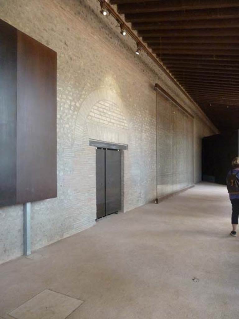 II.7.1 Pompeii. September 2015. Looking west from entrance along south wall.
The door on the left is the entrance to the latrine.
According to Maiuri –
“The waste-water from the swimming pool was used for washing the large latrine on the south side of the southern portico.”
See Notizie degli Scavi, 1939, (p.189)

