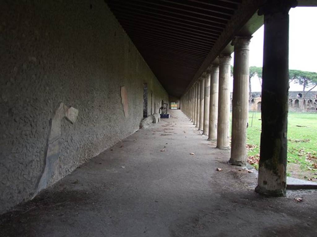 II.7.8 Pompeii. Palaestra. December 2006. Looking east along north portico towards north-east corner.
According to Maiuri – 
“The only wall of the portico that, at the moment of the eruption, preserved its pictorial decoration, was the wall of the north portico, the one which, however, was found completely fallen, other than the last short stretch of just over 14 metres at the far north-east corner.
On the other two long walls of the west and south porticos, and the wall on the east side, nothing was seen other than a minimum trace of decoration.”
See Notizie degli Scavi, 1939, (p.184)
