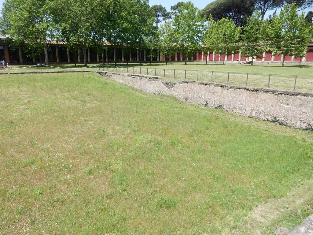 II.7 Pompeii. June 2019. Looking across pool to west portico and north-west corner of Palestra. Photo courtesy of Buzz Ferebee.